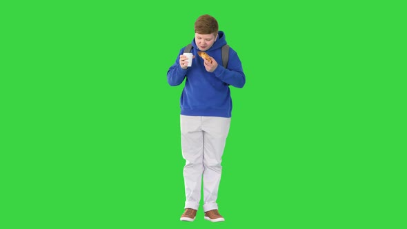 Schoolboy Having a Croissant and Drinking a Soft Drink on a Green Screen Chroma Key