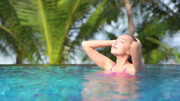 Young asian woman enjoy around outdoor swimming pool for leisure