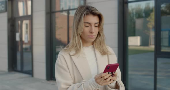 Attractive Woman Using Smartphone While Standing at City Street. Stylish Young Female Person