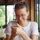 Adult woman in glasses browsing social media on smartphone  - VideoHive Item for Sale