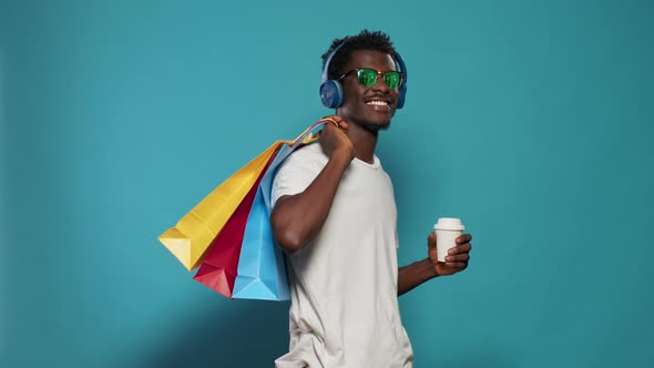 Casual Man Carrying Shopping Bags and Wearing Headphones