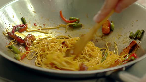 pasta in a frying pan, in oil, with fresh vegetables