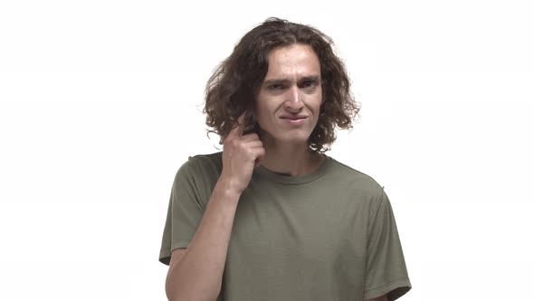 Handsome Caucasian Guy in Casual Tshirt Looking Confused Cannot Hear you Pointing at Ear and Asking