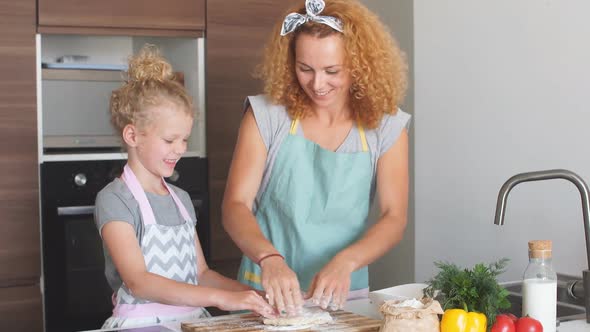 Happy Mother with Little Daughter in Home Kitchen