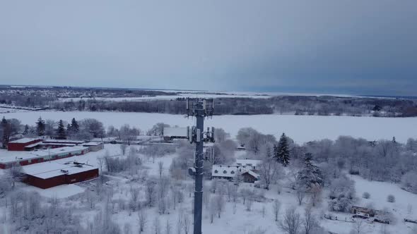 Aerial snow covered radio tower during a winter day