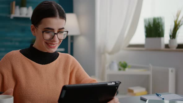 Young Adult Using Digital Tablet with Stylus to Do Remote School Work