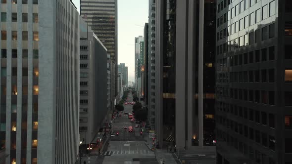 AERIAL: Epic Flight Through Downtown Los Angeles Skyscraper Canyon in Sunset Light with Car Traffic