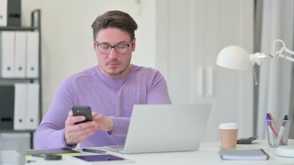 Middle Aged Man Using Smartphone in Office 