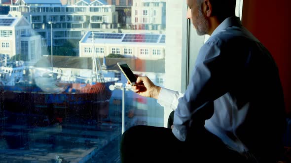 Businessman using mobile phone in hotel room