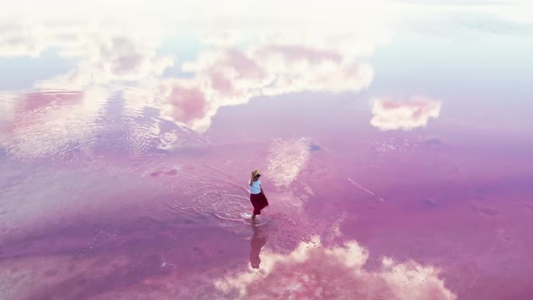 Carefree Woman Joyfully Walking in Water of Amazing Pink Lake