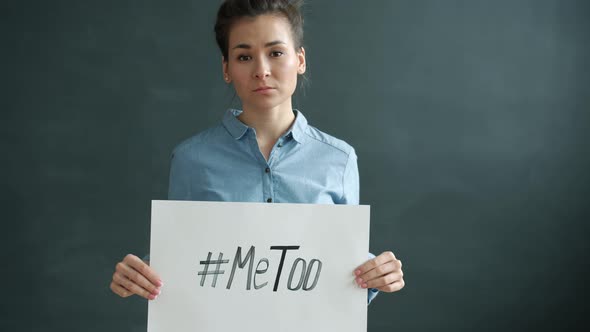 Slow Motion of Beautiful Asian Girl Holding MeToo Hashtag Sign Standing on Black Background