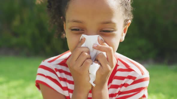 African american girl blowing her nose outside