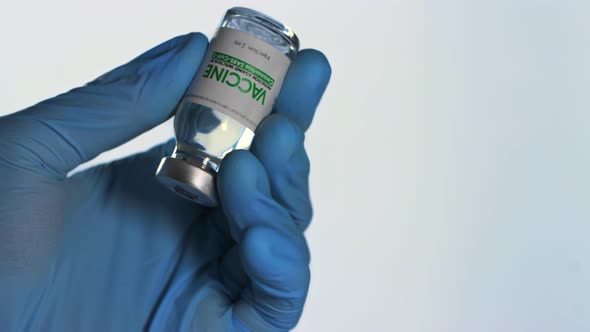 Doctor in Medical Glove Holds in His Hand a Vial of Vaccine for Injection for Coronavirus COVID19