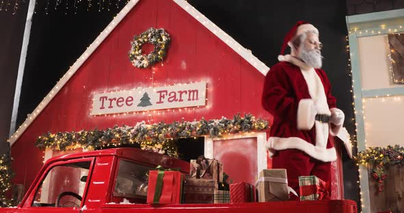 Modern Santa Claus Dancing in Decorated Apartment in a Red Truck with New Year Gifts Near Christmas