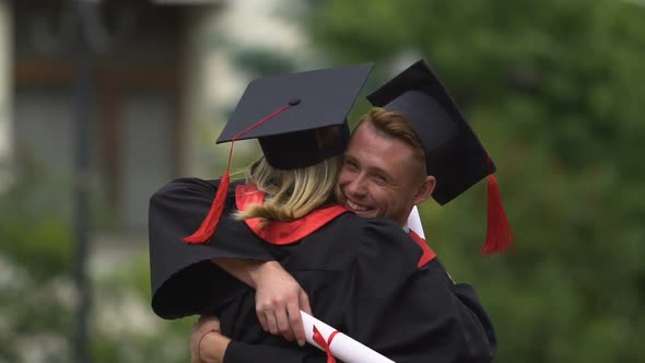 Happy Man Congratulating and Hugging  Young Woman on Graduation Day, Achievement