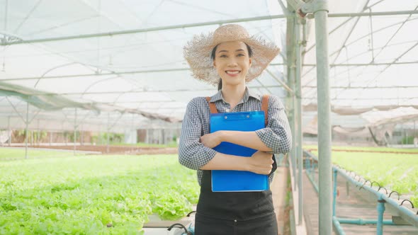 Portrait of beautiful girl farmer working in vegetable hydroponic farm.