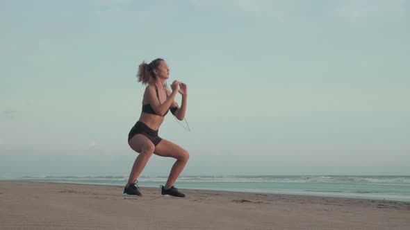 Girl Doing Squats on Beach