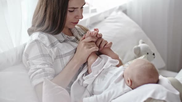 Mother Kissing Feet of Infant Son