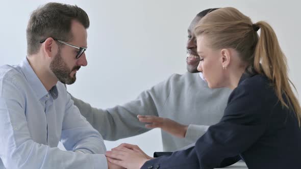 Male and Female Business Person Reassuring Upset Businessman