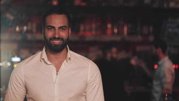 Portrait of Smiling Attractive Man Looking at Camera in a Bar or Beer Pub