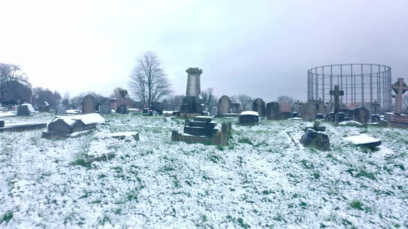 Low drone shot over Grave stones covered in snow