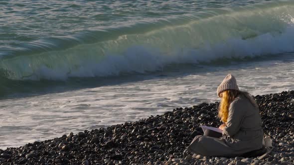 A Girl Reading a Book By the Sea