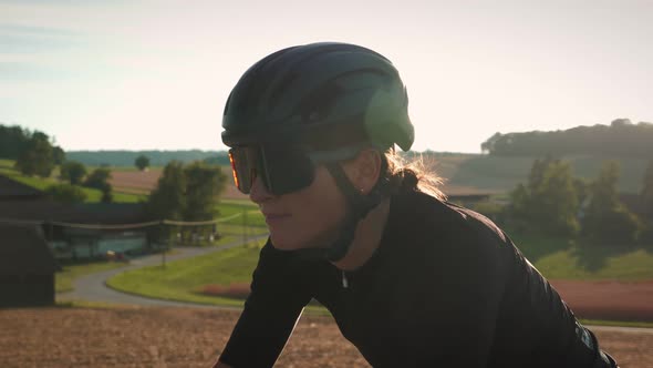 Portrait of female athlete in helmet and sportswear. Sunset Cycling