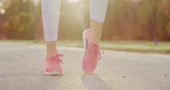 Handheld view of woman stretching her legs before jogging training 