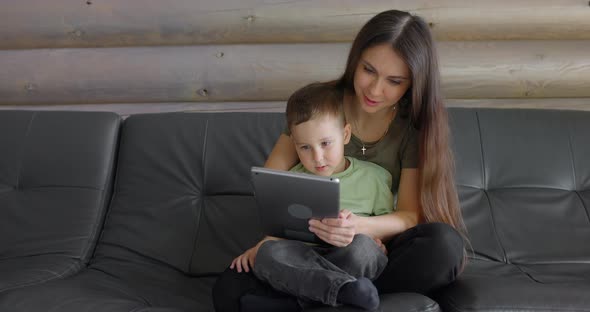 Video of a Young Smiling Mother and Her Sweet Son Playing in a Child Development App on a Digital