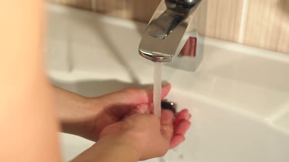 Closeup of a Woman Washing Her Hands in Bathroom