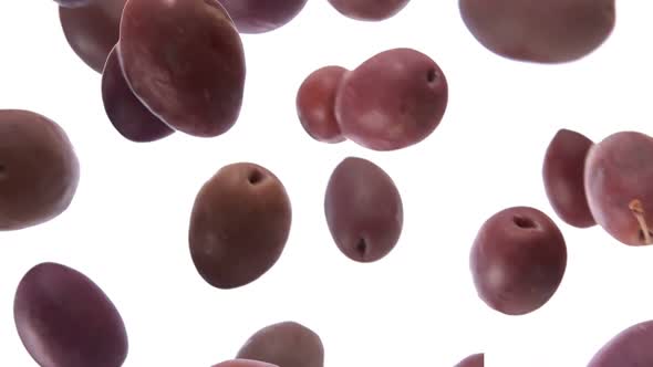 Large Delicious Dark Olives are Falling on the White Background