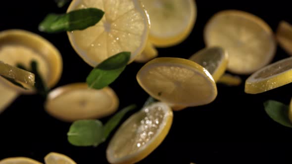 Slow Motion Shot of Flying Mint Leaves and Lemon Slices Collision in the Air