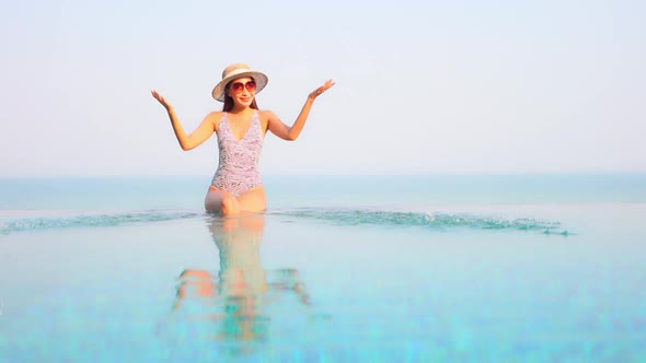 Young asian woman enjoy around outdoor swimming pool for leisure