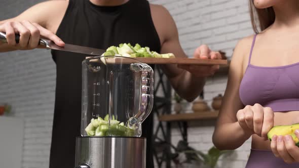 Making Green Juice at Home Male Hands Add Sliced Celery To a Blender in the Kitchen