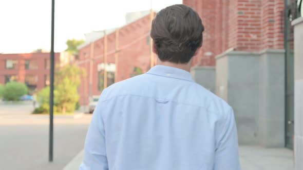 Back View of Man Walking in a Street