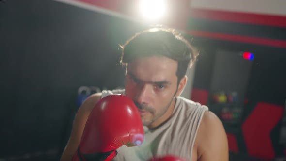 4K Caucasian man athlete do boxing exercise with punching the air at gym