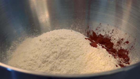 Cocoa Powder Is Poured Into a Steel Bowl of Flour - Closeup