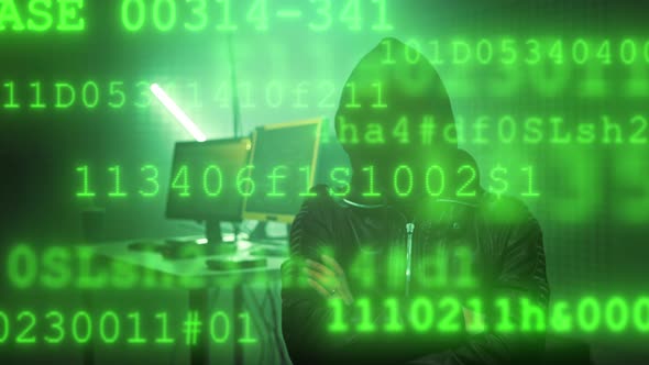 Hacker with Masked Face Working on a Computer for Cyber Attack While Green Binary Hacking Code
