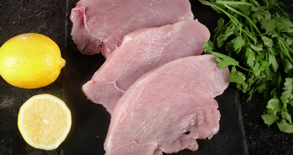 Raw Turkey Fillet with Herbs and Lemon on a Stone Board. 
