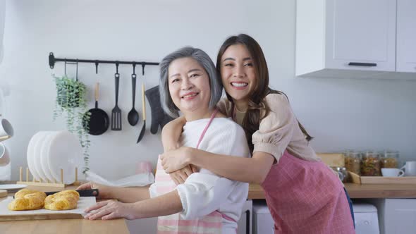 Portrait of Asian lovely family, young daughter stand with old mother enjoy activity at home.