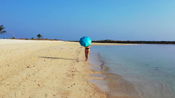 Women tanning on tropical tourist beach voyage by shallow sea and white sand background of Thailand 