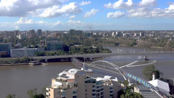 Two jestskis race down the a winding Brisbane river on a sunny day