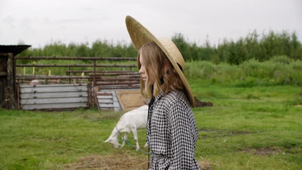Elegant Teen Girl in Hat and Dress Walking in Rural Farm