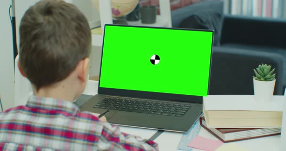 Little Boy Uses Green Screen Chroma Key Laptop for Learning Writes Down Useful Information