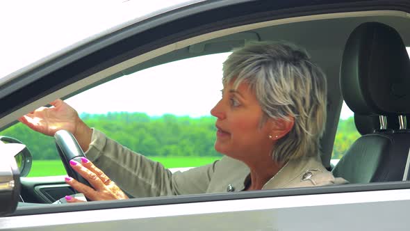 Middle Aged Woman Sits in Car and Complains on Traffic Situation - Car Stands on the Verge of Road