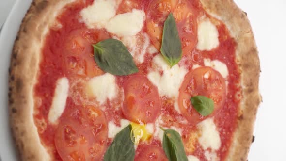 Vertical video: Pizza drizzled with olive oil