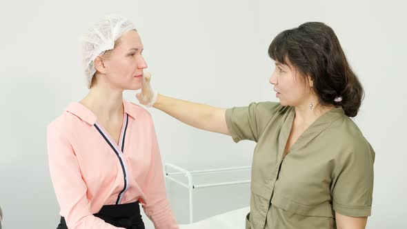 Therapist in Sterile Gloves Examines Beauty Clinic Patient