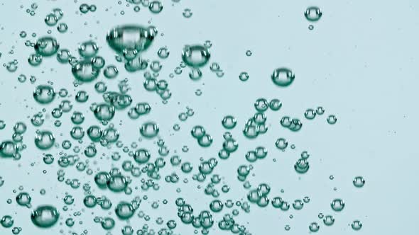 Macro Shot of Air Bubbles in Water Rising Up on Light Blue Background