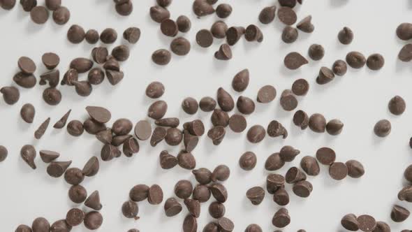 Video of overhead view of multiple chocolate chip over white background