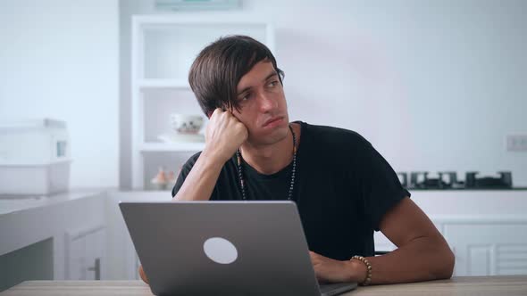 Sad Man Freelancer Looking Stressed Out While Working on Laptop Worried About Problems While Sitting